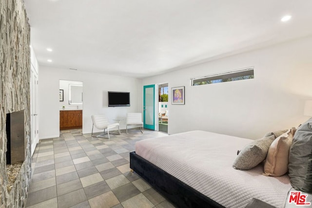 bedroom with ensuite bath and a fireplace