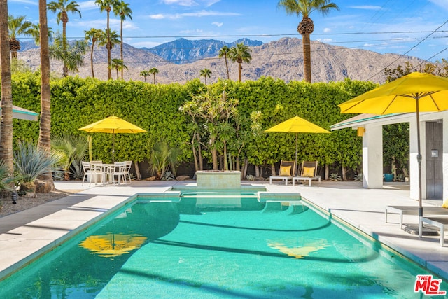 view of swimming pool with a mountain view and a patio