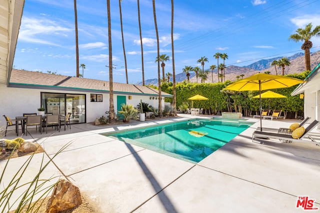 view of swimming pool with a mountain view and a patio area