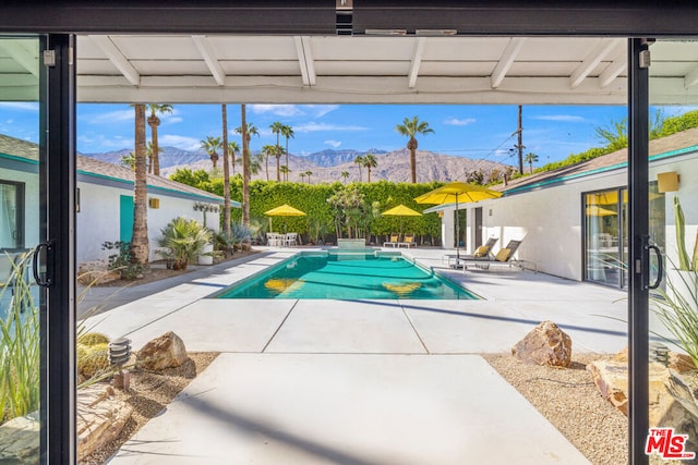 view of pool featuring a patio area and a mountain view