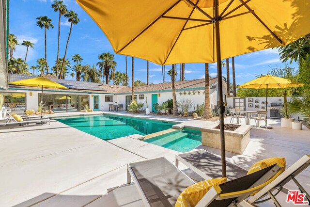 view of pool featuring a fire pit and a patio