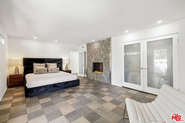 bedroom featuring a large fireplace and french doors