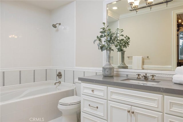 bathroom with tiled bath, crown molding, vanity, and toilet