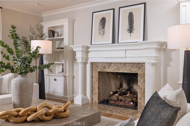 sitting room with crown molding, a fireplace, and light hardwood / wood-style flooring