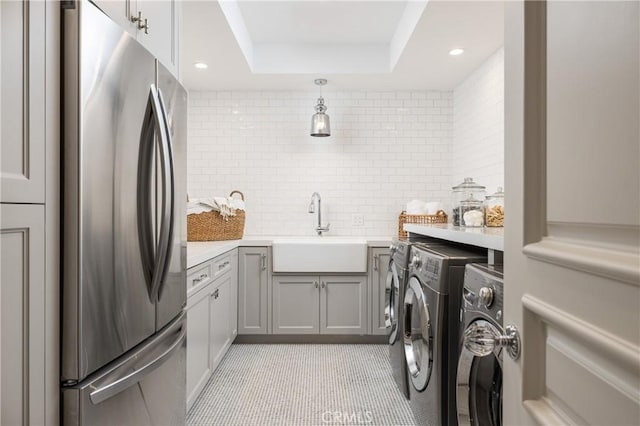 laundry room with separate washer and dryer, sink, and light tile patterned floors