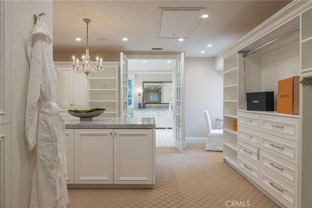 walk in closet with light carpet and a chandelier