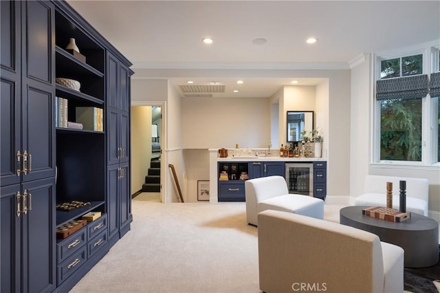 interior space with bar, light carpet, beverage cooler, and ornamental molding