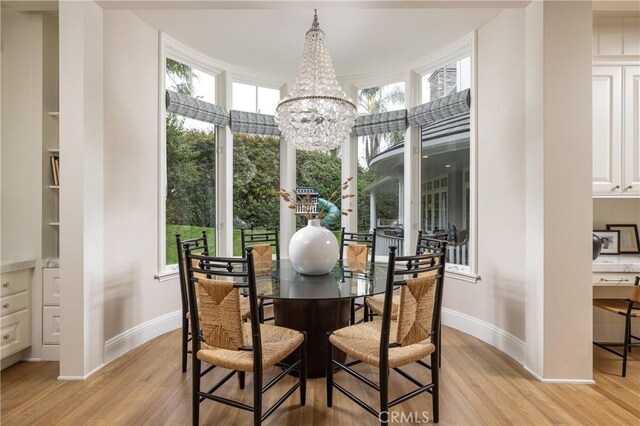 dining room featuring light wood-type flooring and a notable chandelier