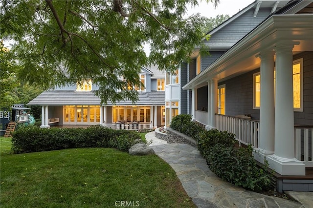 rear view of property with a yard and a porch