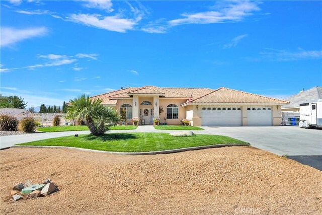 mediterranean / spanish home featuring a front lawn and a garage