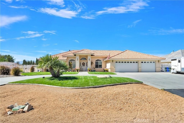 mediterranean / spanish-style home featuring a front yard and a garage