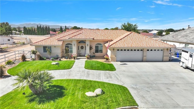 mediterranean / spanish-style house featuring a mountain view, a front lawn, and a garage