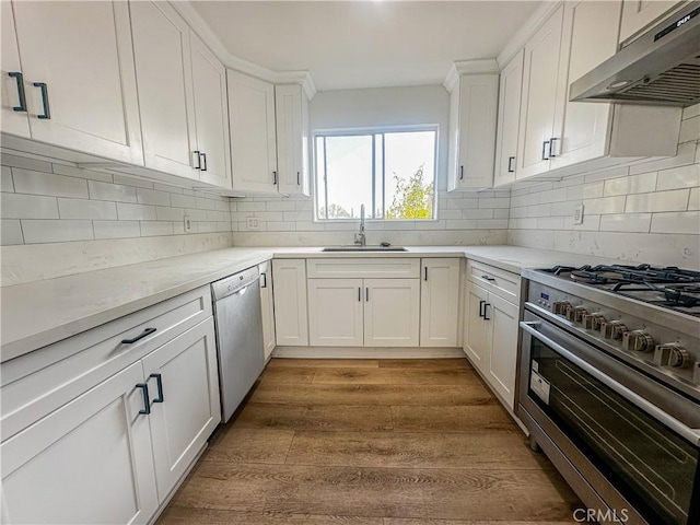 kitchen with sink, stainless steel appliances, white cabinetry, and dark hardwood / wood-style floors