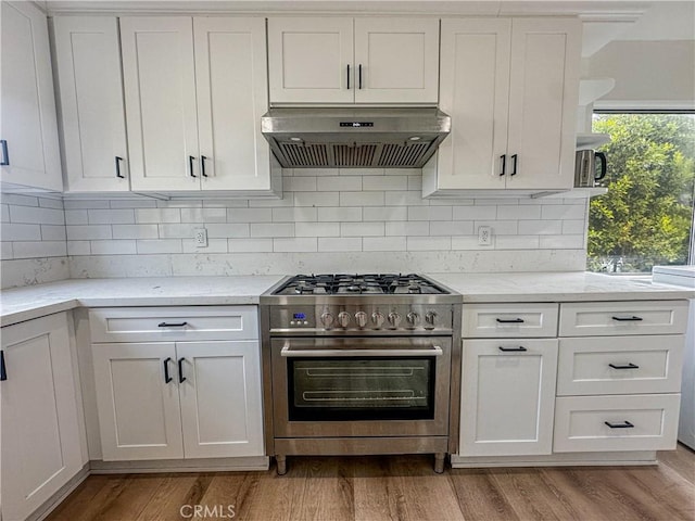 kitchen with white cabinets, stainless steel stove, and ventilation hood