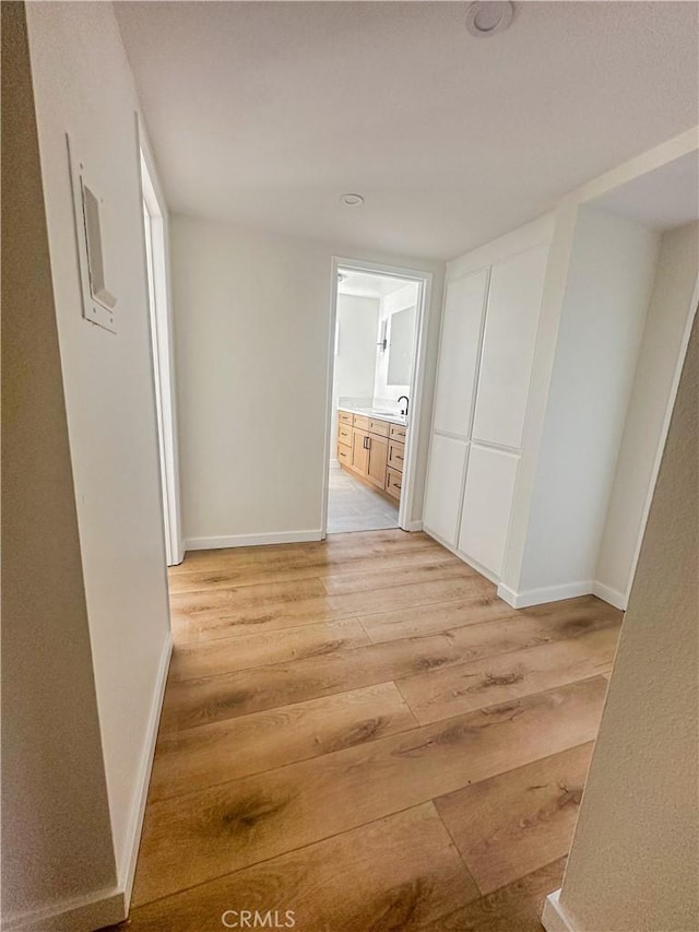 hall with sink and light hardwood / wood-style flooring