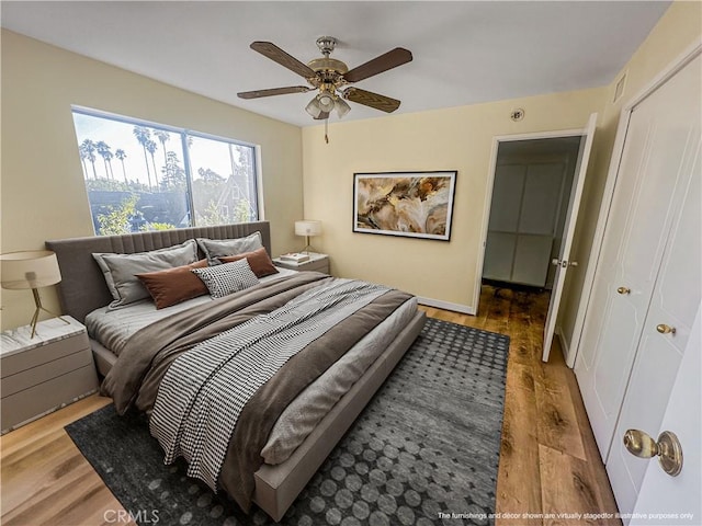 bedroom featuring hardwood / wood-style flooring, ceiling fan, and a closet