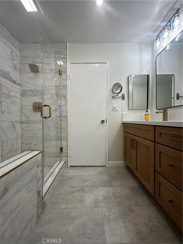 bathroom featuring a shower with door and vanity