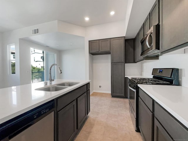 kitchen with sink, light tile patterned floors, and stainless steel appliances