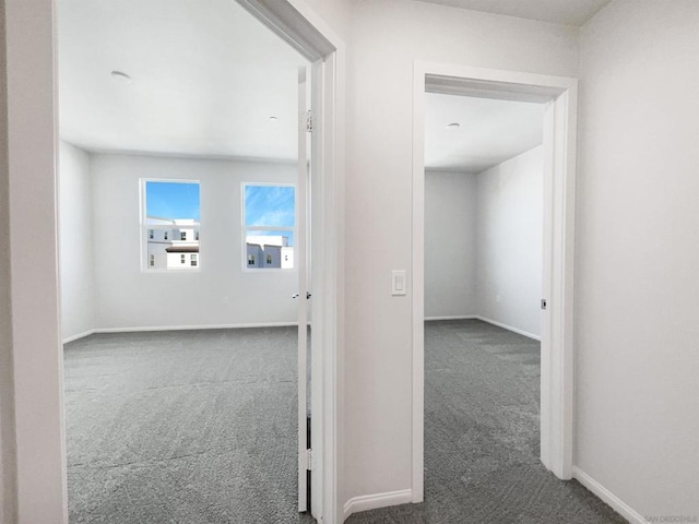 hall with dark colored carpet