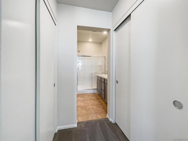 hall featuring dark tile patterned flooring