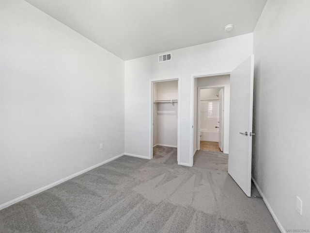 unfurnished bedroom featuring light carpet and a closet