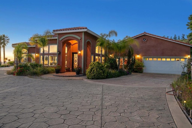 mediterranean / spanish home featuring a garage