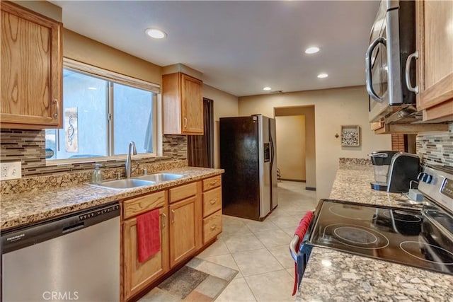 kitchen with tasteful backsplash, sink, light tile patterned floors, and appliances with stainless steel finishes