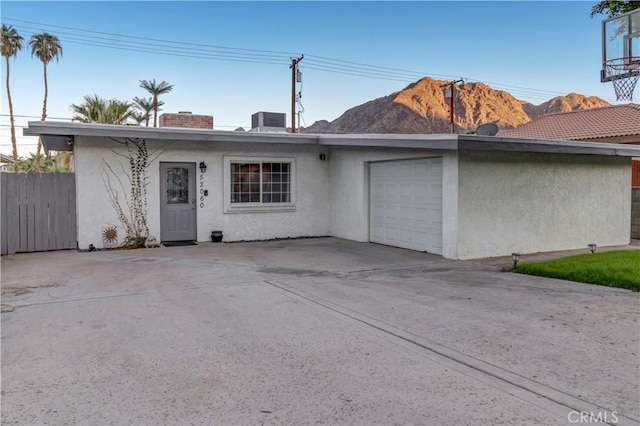 ranch-style house featuring a mountain view, a garage, and central AC