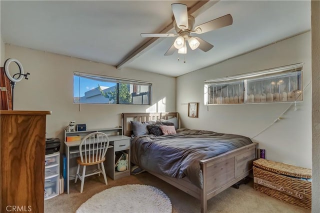 bedroom with beamed ceiling, light carpet, and ceiling fan