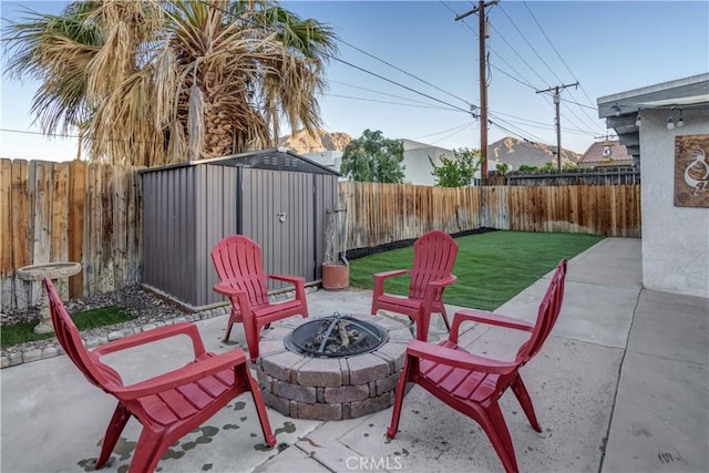 view of patio / terrace with a storage shed and an outdoor fire pit