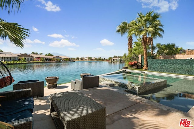 view of pool with a patio, a water view, and an in ground hot tub