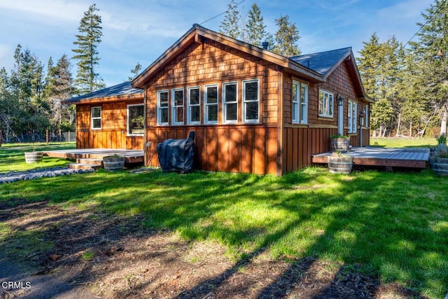 back of house with a lawn and a deck