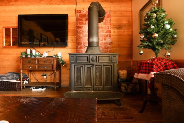 living room featuring a wood stove, wood walls, and wood-type flooring