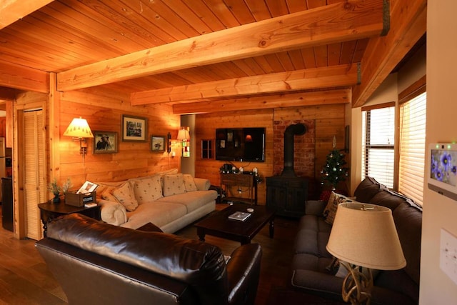 living room featuring dark wood-type flooring, beam ceiling, wooden ceiling, a wood stove, and wood walls