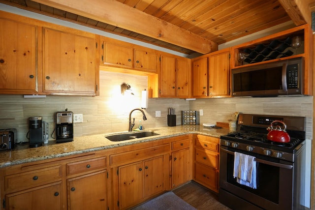 kitchen with sink, light stone counters, beamed ceiling, decorative backsplash, and appliances with stainless steel finishes