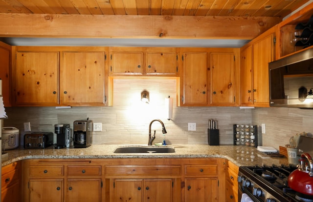 kitchen with decorative backsplash, light stone counters, wooden ceiling, and sink