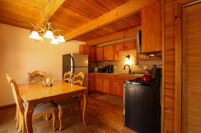 kitchen featuring stainless steel fridge, dark hardwood / wood-style flooring, black range oven, and a notable chandelier