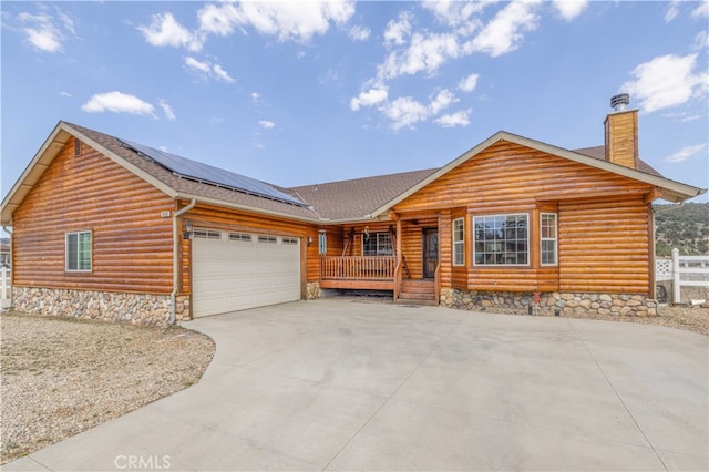 log-style house featuring solar panels, a porch, and a garage