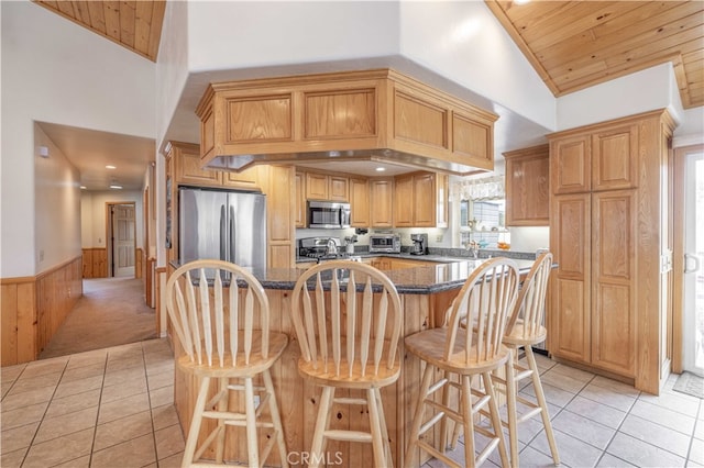 kitchen featuring light tile patterned flooring, stainless steel appliances, wooden ceiling, and a kitchen island