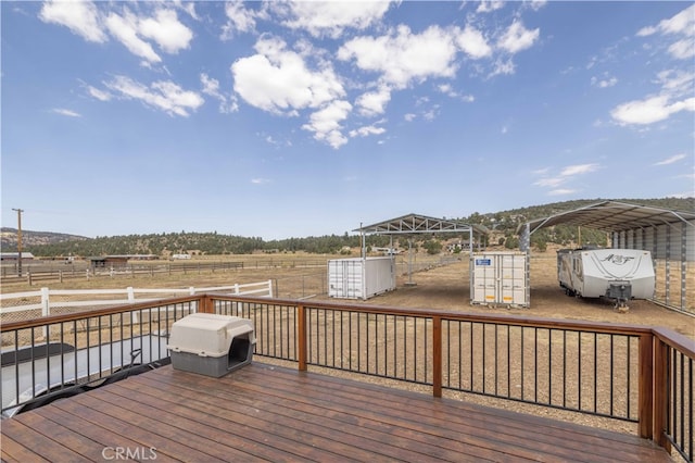 wooden deck featuring a storage shed and a rural view