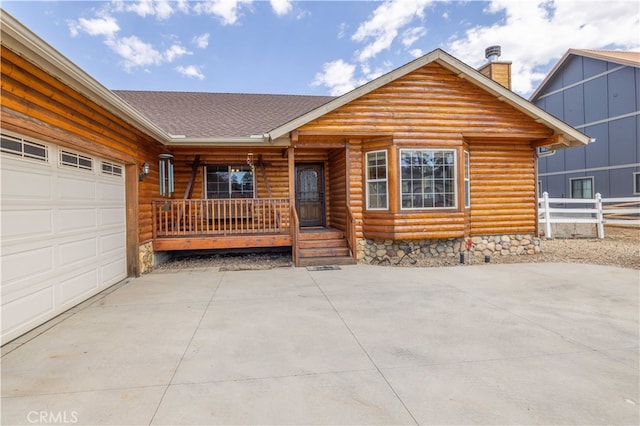 cabin with a garage and covered porch