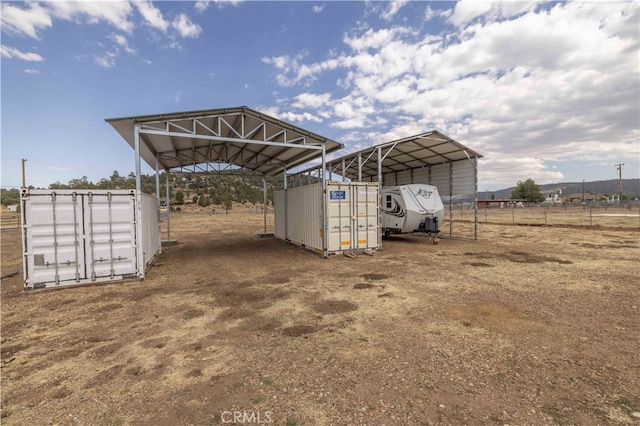 view of outbuilding with a rural view and a carport