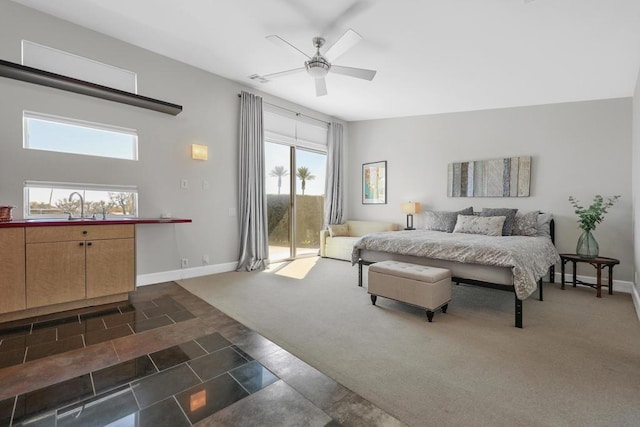 bedroom featuring access to exterior, ceiling fan, sink, and dark colored carpet