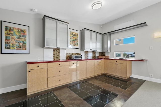 kitchen with light brown cabinets and tasteful backsplash