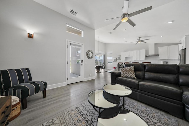 living room featuring hardwood / wood-style floors, ceiling fan, and lofted ceiling