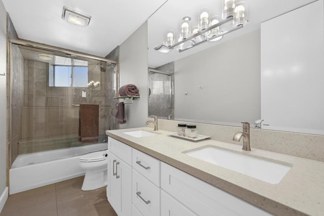 full bathroom featuring shower / bath combination with glass door, vanity, toilet, and tile patterned flooring