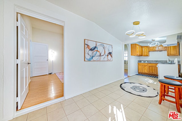 kitchen featuring lofted ceiling, sink, and light hardwood / wood-style flooring