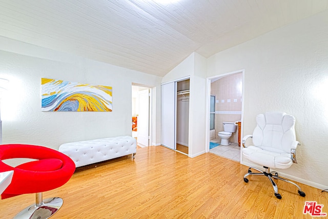 living area with hardwood / wood-style flooring and vaulted ceiling