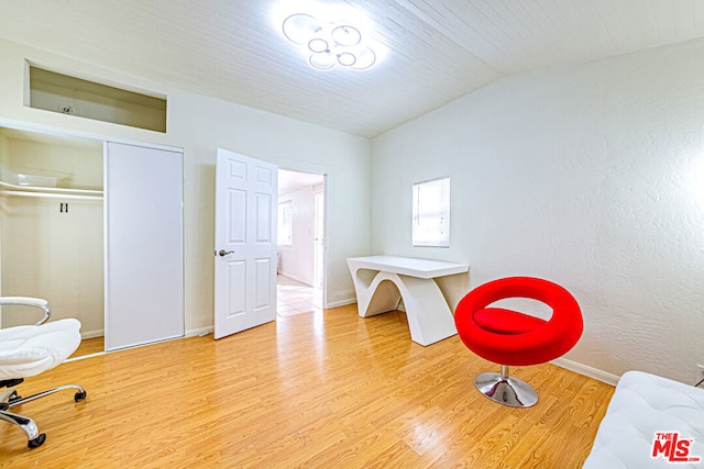 sitting room with vaulted ceiling and light hardwood / wood-style flooring