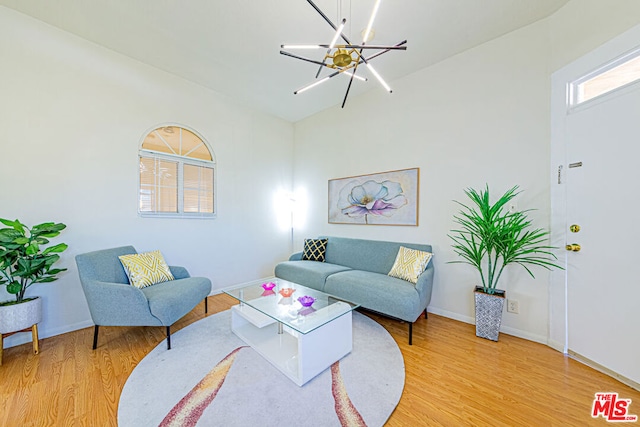 living room with light hardwood / wood-style floors and a chandelier